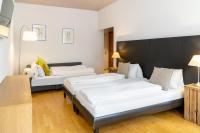 VilligenHotel zum Hirschen的有两张床和一张桌子的酒店房间