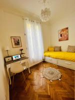 尼斯Cœur d&#39;Azur Appartement的一间卧室配有黄色的床和一张书桌