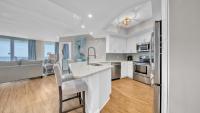 德斯坦St Maarten 907 a Newly Renovated Luxury Beach Front 3 Bedroom 9th Floor Private Elevator的一间带白色橱柜的厨房和一间带沙发的厨房