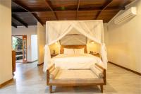 福尔图纳Chachagua Rainforest Hotel &amp; Hot Springs的一间卧室设有一张带木制天花板的天蓬床。