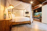 福尔图纳Chachagua Rainforest Hotel &amp; Hot Springs的别墅内一间卧室配有一张天蓬床
