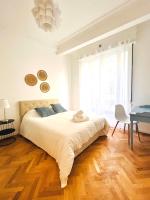 尼斯Cœur d&#39;Azur Appartement的白色卧室配有一张大床和一张书桌