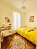 尼斯Cœur d&#39;Azur Appartement的一间卧室配有黄色的床和一张书桌