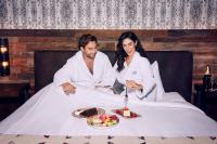 拉斯维加斯Silverton Casino Lodge的坐在床上吃一盘食物的男人和女人