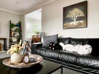 汉密尔顿M&amp;K Home with central air condition, 4 bedrooms, by Chartwell Shopping Centre的客厅配有黑色皮沙发,里面装满了动物