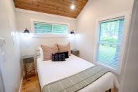 加特林堡Farmhouse Tiny home with fishing Pond - Oak Cabin的卧室里有一张白色的床，还有两扇窗户