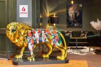 莱比锡Amedia Hotel &amp; Suites Leipzig, Trademark Collection by Wyndham的狮子雕像在客厅里