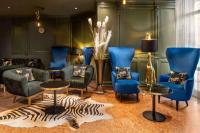莱比锡Amedia Hotel &amp; Suites Leipzig, Trademark Collection by Wyndham的客厅配有蓝色椅子和斑马地毯