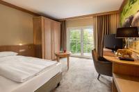 莱比锡Amedia Hotel &amp; Suites Leipzig, Trademark Collection by Wyndham的一间配有床和电脑的书桌的酒店房间
