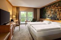 莱比锡Amedia Hotel &amp; Suites Leipzig, Trademark Collection by Wyndham的一间卧室配有两张床,还有一幅大型豹画