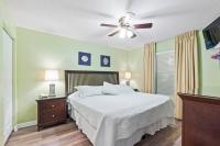 德斯坦Beachfront condo at Pelican Beach的带床和吊扇的卧室