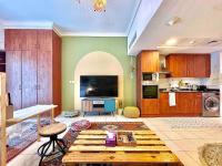迪拜Rustic Elegance By The Lake Studio Cabin In Jlt的带桌子的客厅和厨房
