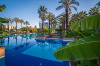 拉瑞Concorde De Luxe Resort Lara Antalya- Prive Ultra All Inclusive的有棕榈树的游泳池和一栋建筑