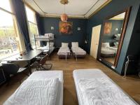 阿姆斯特丹Amsterdam Rembrandt Square city center Hotel的客房设有两张床、一张桌子和镜子