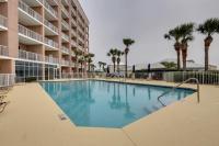 格尔夫海岸Gulf Shores Condo with Balcony 2 Mi to Fort Morgan!的酒店前的棕榈树游泳池