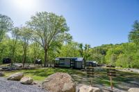 加特林堡Farmhouse Tiny home with fishing Pond - Oak Cabin的树林里有岩石和树木的露营地