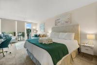 德斯坦Sandestin Bayfront Studio with balcony and breathtaking views的卧室里有一张大床，上面铺着绿色毯子