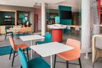 罗斯维尔Avid Hotels - Roseville - Minneapolis North by IHG的配有桌椅和电视的餐厅
