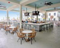 默特尔比奇Holiday Inn Club Vacations Myrtle Beach Oceanfront的有桌椅和酒吧的餐厅