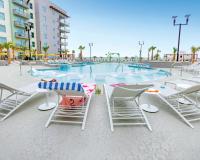 默特尔比奇Holiday Inn Club Vacations Myrtle Beach Oceanfront的游泳池配有椅子、桌子和桌椅