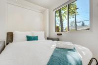 科罗拉多斯普林斯Cargo Casita Shipping Container Tiny Home的卧室里有一张白色的大床，床边有一扇窗户