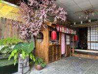 大叻SAKURA House ĐÀ LẠT的商店门前一棵开着粉色花朵的树