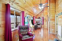 加特林堡Cabin In The Smokeys的客厅配有吊扇和椅子