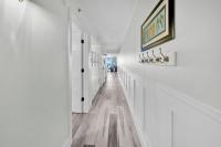 德斯坦Beautiful Updated Pelican Beach Unit!!!的白色的走廊设有白色的墙壁和木地板