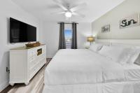 德斯坦Beautiful Updated Pelican Beach Unit!!!的白色卧室配有白色的床和平面电视