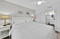 德斯坦Beautiful Updated Pelican Beach Unit!!!的白色卧室配有白色的床和浴室