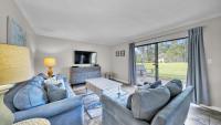 德斯坦Cozy renovated ground floor unit - Golf Villa - on the Golf Course的客厅设有2张蓝色的沙发和大窗户