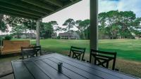 德斯坦Cozy renovated ground floor unit - Golf Villa - on the Golf Course的享有田野景致的门廊上的桌椅