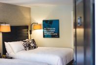 费尔菲尔德Hotel Hi-Ho - Contactless Check-In的卧室配有一张床,墙上挂着一张海报