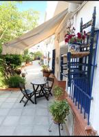 塞维利亚Típico y pintoresco patio de vecinos, con encanto的庭院配有桌椅和蓝色围栏。