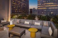 纽约Hampton Inn by Hilton New York Times Square的屋顶庭院配有沙发和桌子,并拥有建筑