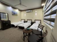巴格达SAFIR BAGHDAD HoTEL的带三张床和桌椅的房间