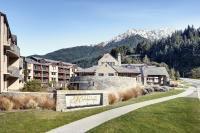 皇后镇Rendezvous Heritage Hotel Queenstown的山间的一个度假胜地,在草地上有一个标志