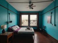 圣地亚哥Lucky D&#39;s Youth and Traveler&#39;s Hostel的蓝色的卧室设有床和窗户