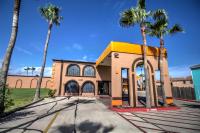 南帕诸岛South Padre Island Inn的一座前面有棕榈树的建筑