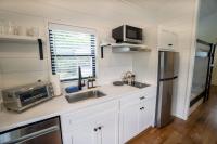加特林堡Creekside Modern Tiny Home - Firepit - Racoon Cabin的配有白色橱柜和不锈钢冰箱的厨房