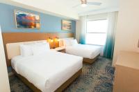 默特尔比奇Holiday Inn Club Vacations Myrtle Beach Oceanfront的有两张床和一扇窗户的酒店房间
