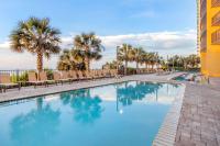 默特尔比奇Hilton Grand Vacations Club Anderson Ocean Myrtle Beach的度假村内带椅子和棕榈树的游泳池