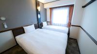 Toyoko Inn Shin-osaka Higashi-mikuni Ekimae客房内的一张或多张床位