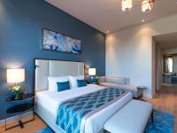 迪拜Rixos The Palm Hotel &amp; Suites - Ultra All Inclusive的卧室里有一张大床，墙壁是蓝色的