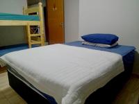 博尼图Casa Em Busca的一张床上放着一个蓝色枕头