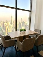迪拜Ora Place JBR的配有大窗户的客房内的桌椅