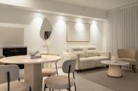埃拉特Nathan&#39;s Suites On The Beach的带沙发、桌子和椅子的客厅