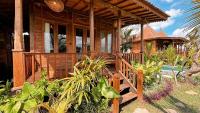 乌布Jagadhita Villas Ubud Bali的木屋设有门廊和游泳池