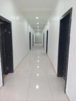 贝宁城Tovia Hotel and Suite Limited的空的走廊,有门,铺着瓷砖地板