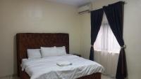 贝宁城Tovia Hotel and Suite Limited的一间卧室配有一张床,上面有电话